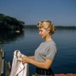 Camaro Vintage Mods - woman holding white textile standing beside body of water