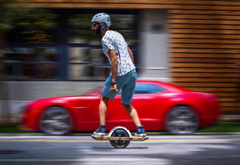 Camaro Electric - a man riding a skateboard down a street