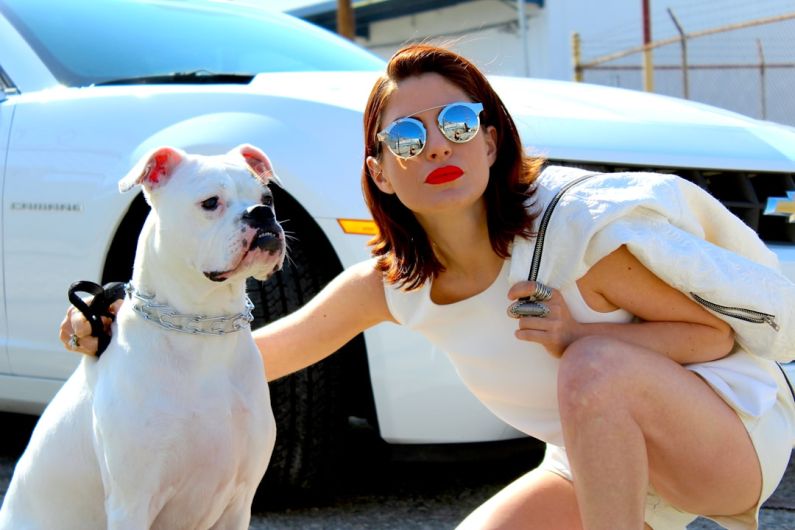 Camaro Lifestyle - woman in white tank top wearing sunglasses sitting on white car during daytime